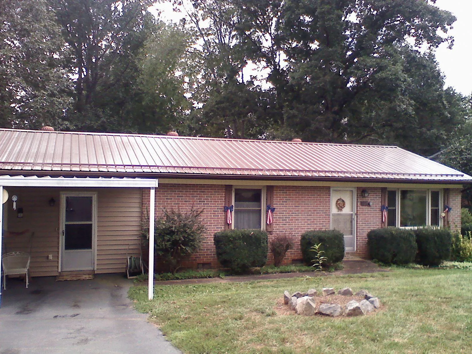 Bronze metal roof and carport on a brick ranch home — Roof Repair work by our crew in Corbett